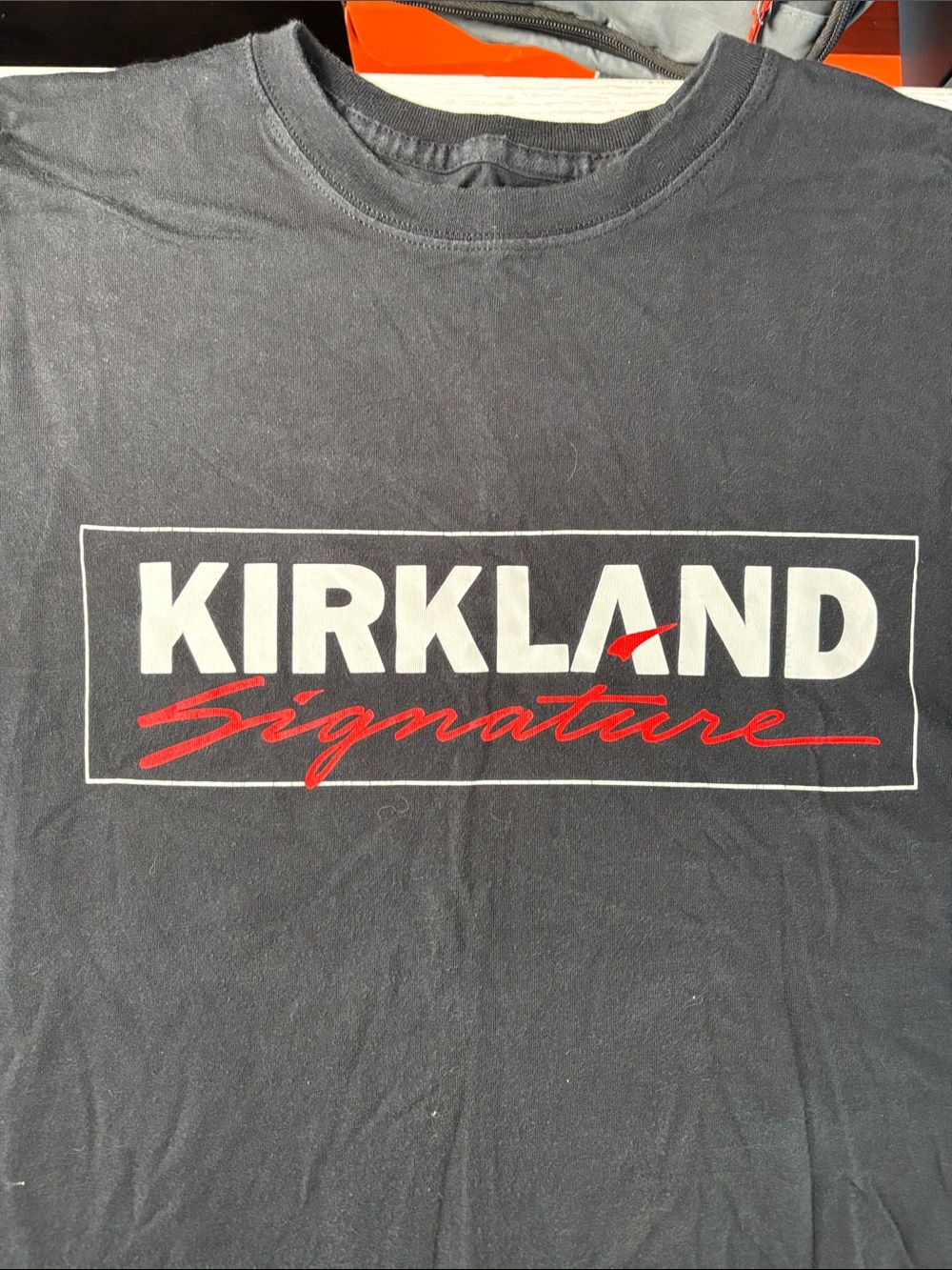 Kirkland Signature Black Tee with White Block Logo and Red Script